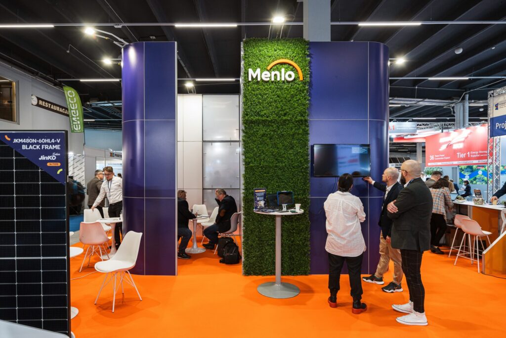 Zabudowa targowa w stylu nowoczesnym z panelami imitującymi bukszpan oraz dedykowanym oświetleniem. Stoisko marki Menlo