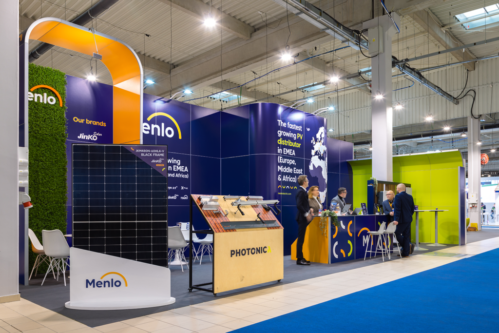 Zabudowa targowa w stylu nowoczesnym - stoisko marki Menlo w kolorach granatu, zieleni i pomarańczy